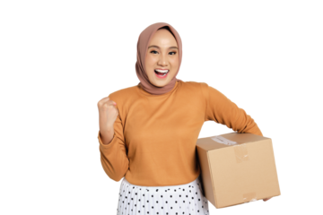 Excited young Muslim woman in hijab holding cardboard box and celebrating success with clenched fist isolated on transparent background