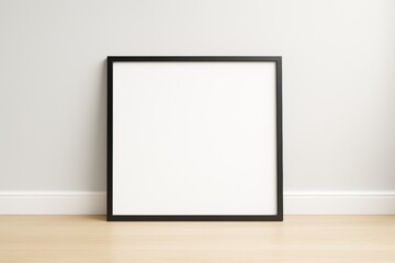 Blank black frame leaning against light wall on wooden floor in modern empty room interior for mockup or branding presentation concept.