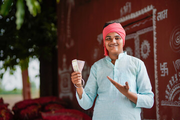 happy indian farmer showing money