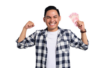 Happy young man in checkered shirt holding Indonesian rupiah money and celebrating success with...