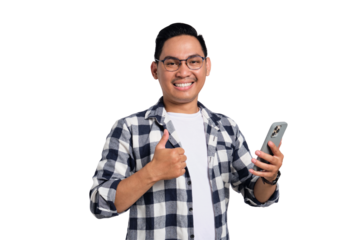 Confident young man in glasses giving thumbs up while holding smartphone and smiling at camera isolated on transparent background