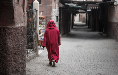 the passerby in the red dress in the ancient alleys of the old city in the early morning