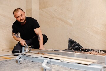 Construction worker cutting ceramic tile using manual tile cutter