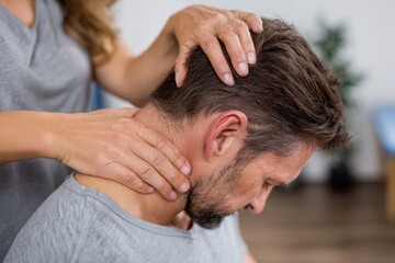 Fototapeta premium Physical therapist treating a patient, with neck therapy in a clinic office.