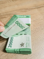 Pile of 20,000 Indonesian Rupiah banknotes.
Preparations for sharing good fortune during Eid...
