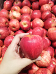 A close-up of a fresh red apple held in hands.
Healthy living and eating lifestyle.