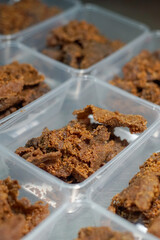 Close up of golden brown, crispy beef pieces packed in clear plastic containers