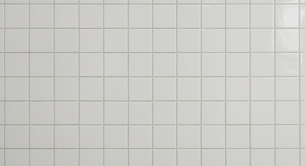 White square ceramic tiles on a wall with light grout lines showing a glossy surface