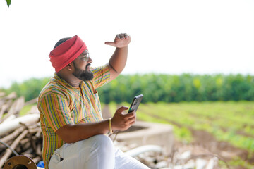 Happy indian farmer using smartphone