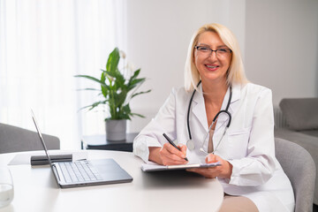 Portrait of smiling family doctor in white coat and stethoscope visit patient at home.