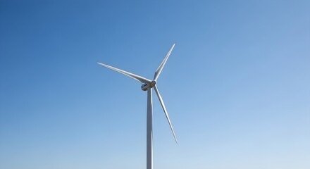Wind turbine against a clear blue sky, generating clean energy