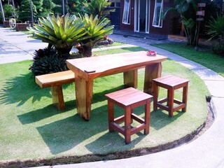 Set up a layout of wooden tables and chairs for an outdoor restaurant or cafe
