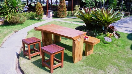 Set up a layout of wooden tables and chairs for an outdoor restaurant or cafe