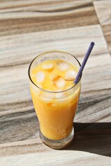 mango juice drink in a glass that is foggy and looks very fresh