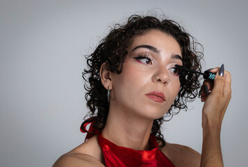 Close-up of young girl with curly hair applying mascara