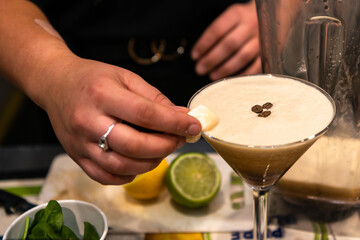 A coffee martini being prepared, showing the hand of the bartender