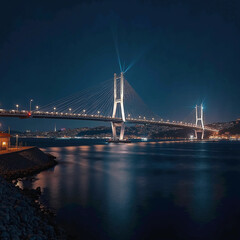 Nighttime illuminated modern suspension bridge spanning across calm waters and city lights