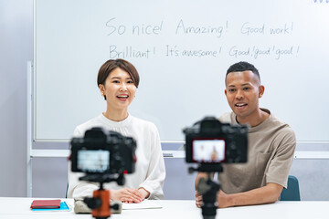 A black man and a Japanese woman filming a video