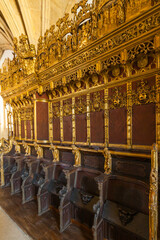 A grand interior featuring ornate wooden pews with rich red upholstery