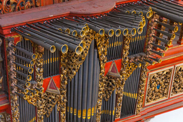 A close-up of ornate organ pipes with golden detailing
