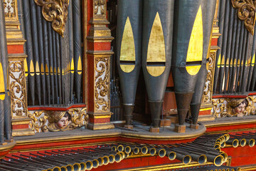 A close-up of ornate organ pipes with golden detailing