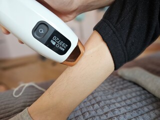 Skin treatment in progress using a handheld device for hair removal at home