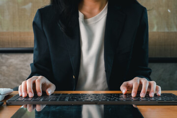 Close-up of a professional typing on a keyboard, highlighting modern office work and technology.