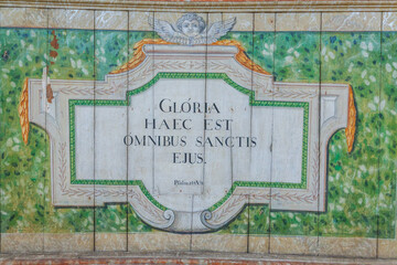 A vibrant mural featuring a Latin inscription, 