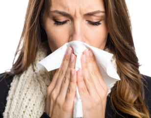 Sick woman blowing nose with tissue showing cold, flu, allergies and illness symptoms