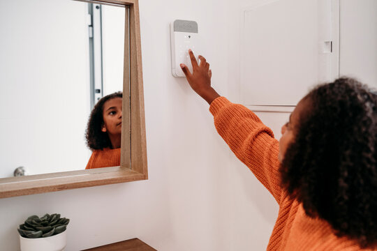 Girl putting code in alarm system at home