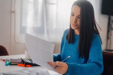 Focused accountant managing budget and analyzing financial documents at home office