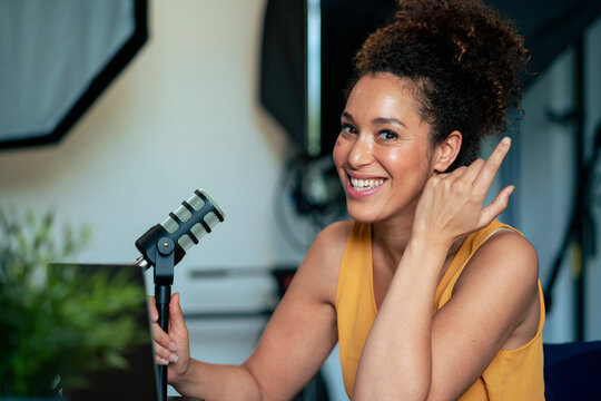 Happy radio presenter with microphone in studio