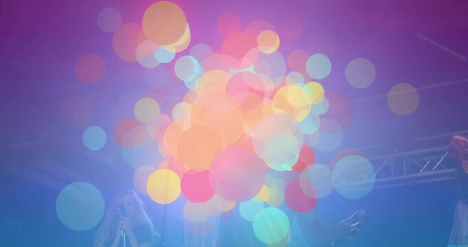 Male singer singing as spotlights shifting revealing drifting colorful bokeh accentuating concert