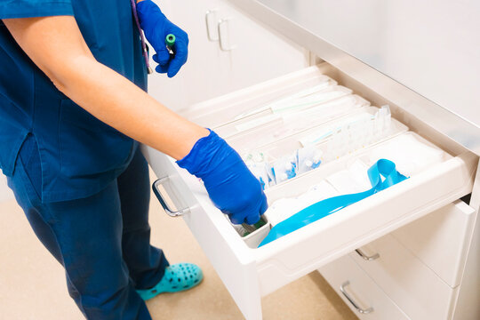 Mature nurse taking inventory and restocking medical supplies at hospital