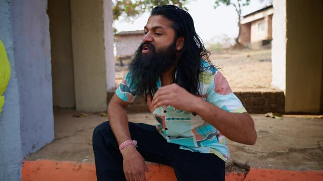 Long haired man gestures broadly talking at rural area
