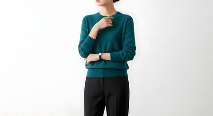 woman in teal sweater and black pants.