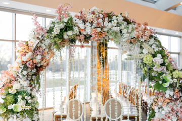 Beautiful round arch of different flowers close up. Indoor wedding decorations for marriage...