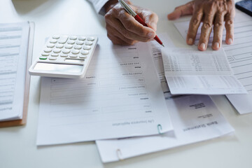 life insurance agent checking savings book to calculate life insurance premiums before advice to customer to make life insurance contract