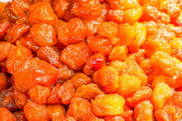 A vibrant pile of dried apricots (Prunus armeniaca) with glossy orange surfaces, ideal for...