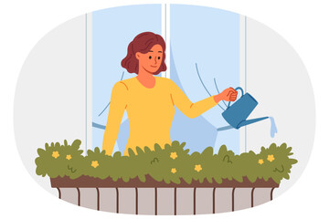 Woman waters flowers, standing on balcony near window to decorate facade of building with greenery and flowers. Girl takes care of plants from balcony, being interested in gardening and botany.