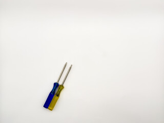 Two small colored plastic screwdrivers on a white background, blue and yellow. copy space, flay lay, top view. High quality photo.