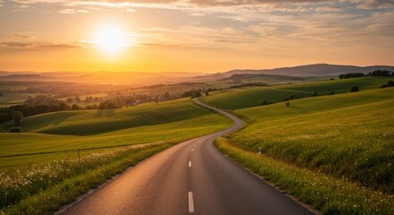 Fototapeta premium Winding Asphalt Road Through Green Hills at Sunset
