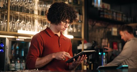 Order, tablet and thinking with bartender in restaurant at night for hospitality or service. App, bill and planning with waiter in cafe or coffee shop for alcohol sales invoice as barman or server