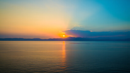 Naklejka premium Tranquil Sunset Over a Serene Ocean with Vibrant Colors