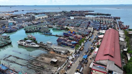 large ships lined up in Jakarta harbor with the hustle and bustle of local fishermen