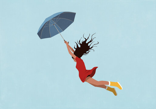 Woman with arms raised holding umbrella, flying against blue background
