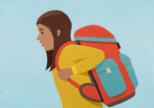 Side view of school girl with large backpack against blue background
