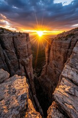 The sun setting over a rugged canyon, casting deep shadows and golden highlights