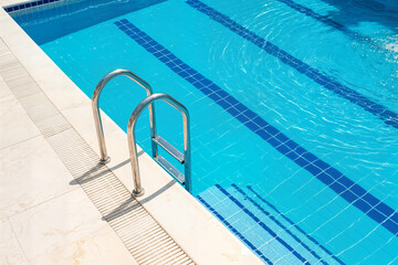 swimming pool concept ladder stainless handrails stairs into the swimming pool concept blue water and sunlight blik of sun vacation relax healthy lifestyle sport concept havuz