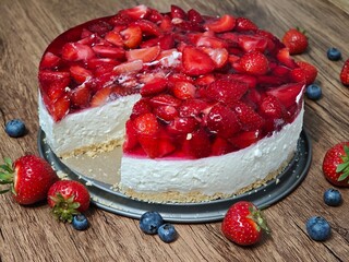 Sweet yogurt cake with red jelly and strawberries